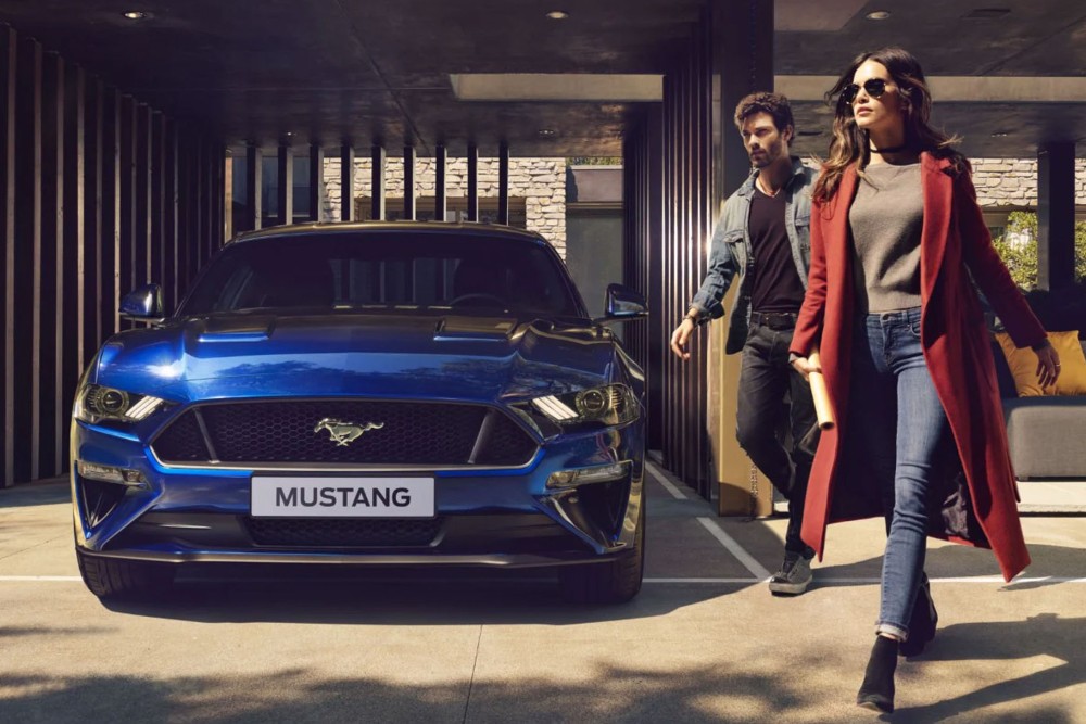 Ford Mustang albastru parcat în fața casei