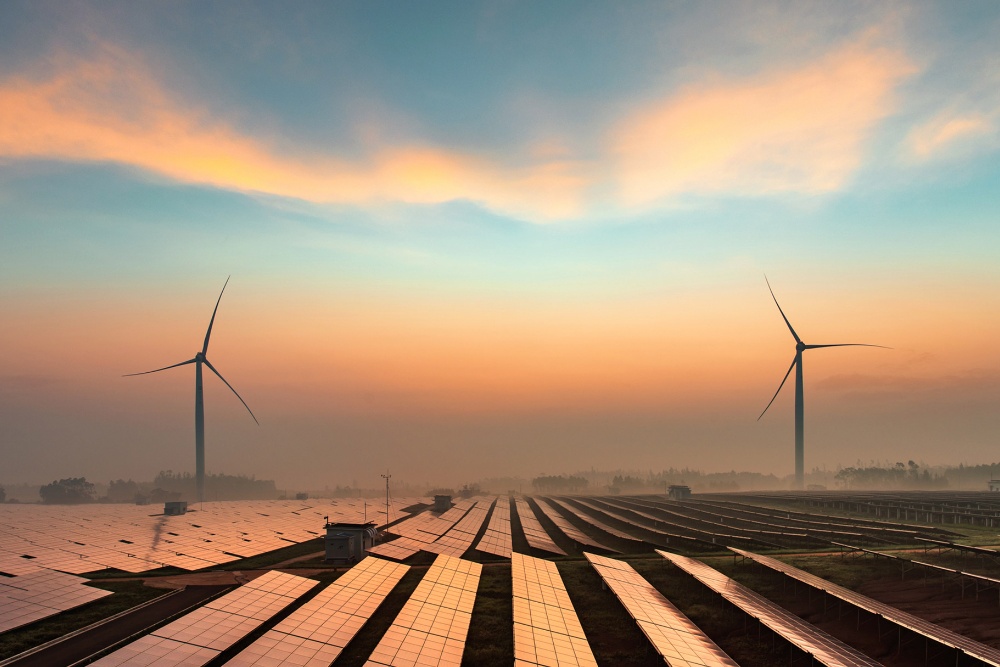 Surse de energie regenerabilă, turbine eoliene și panouri solare, la asfințt.