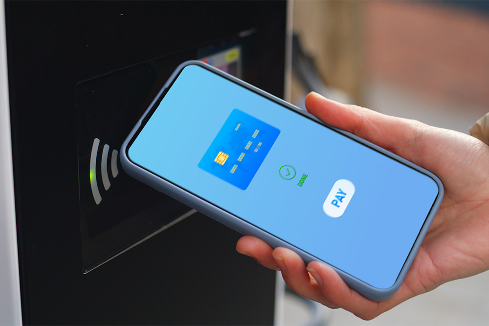 Un smartphone utilizat la un punct public de încărcare pentru vehicule electrice pentru plată contactless.  