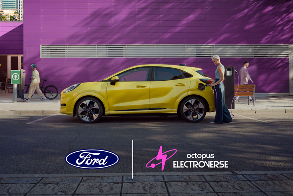 Vedere laterală a unui Ford Puma Gen-E electric galben, conectat la un punct public de încărcare.