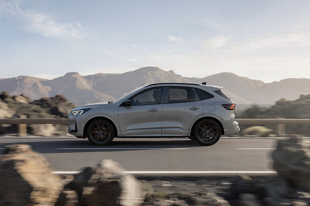 Un Ford Kuga argintiu, condus pe un traseu montan pitoresc. 