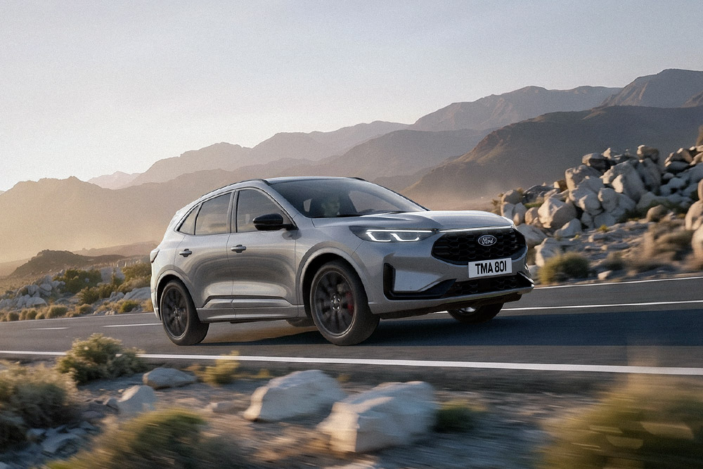 Ford Kuga de culoare argintie, într-un peisaj montan cu stânci.