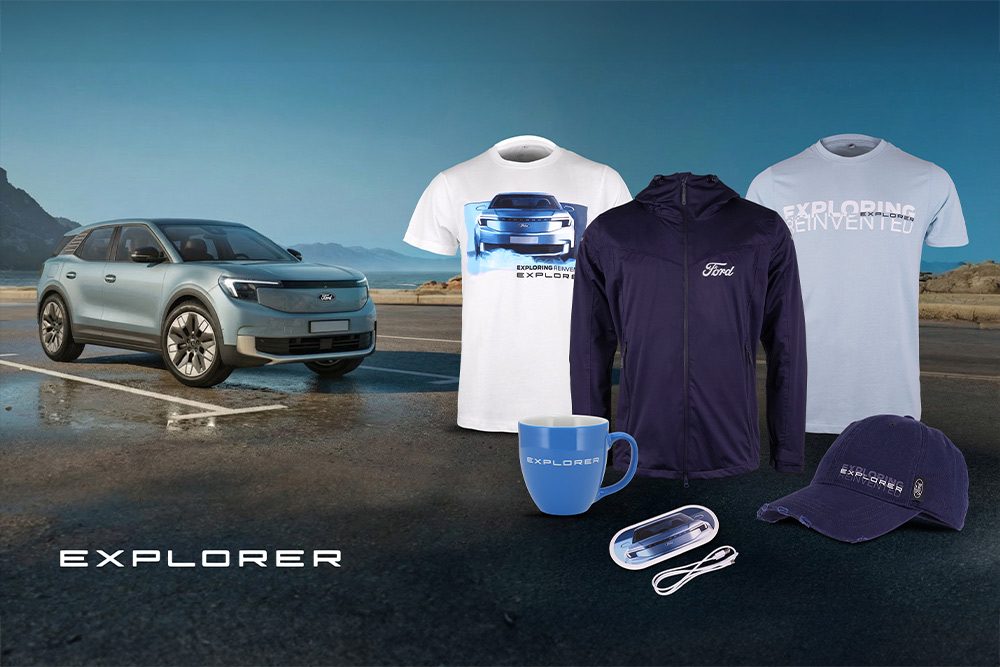 Colecție de produse Ford care prezintă diverse vehicule Ford în fundal, cu umbrelă, căni și articole de îmbrăcăminte cu marca Ford.