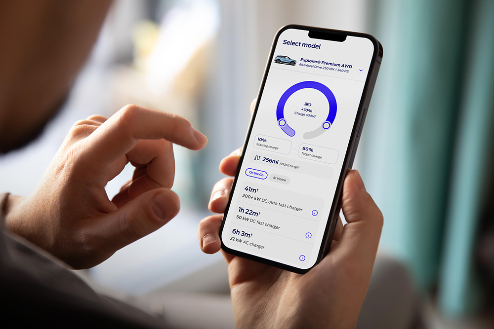 Persoană folosind informatii de pe site-ul Ford EV Life pe telefonul mobil.