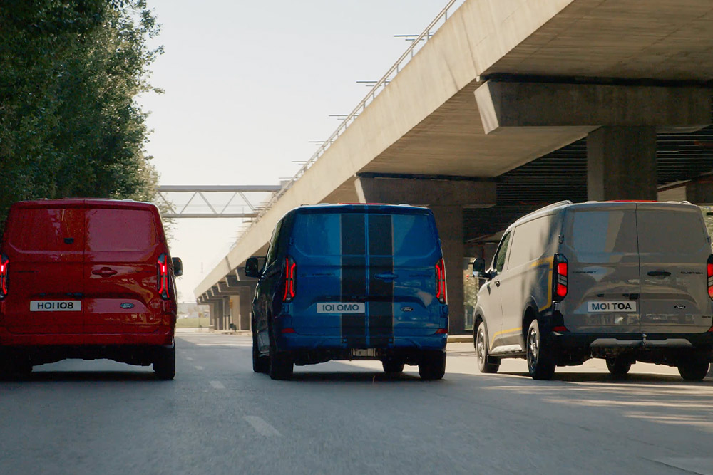 Trei Ford Transit Custom Van conduse  pe autostradă.