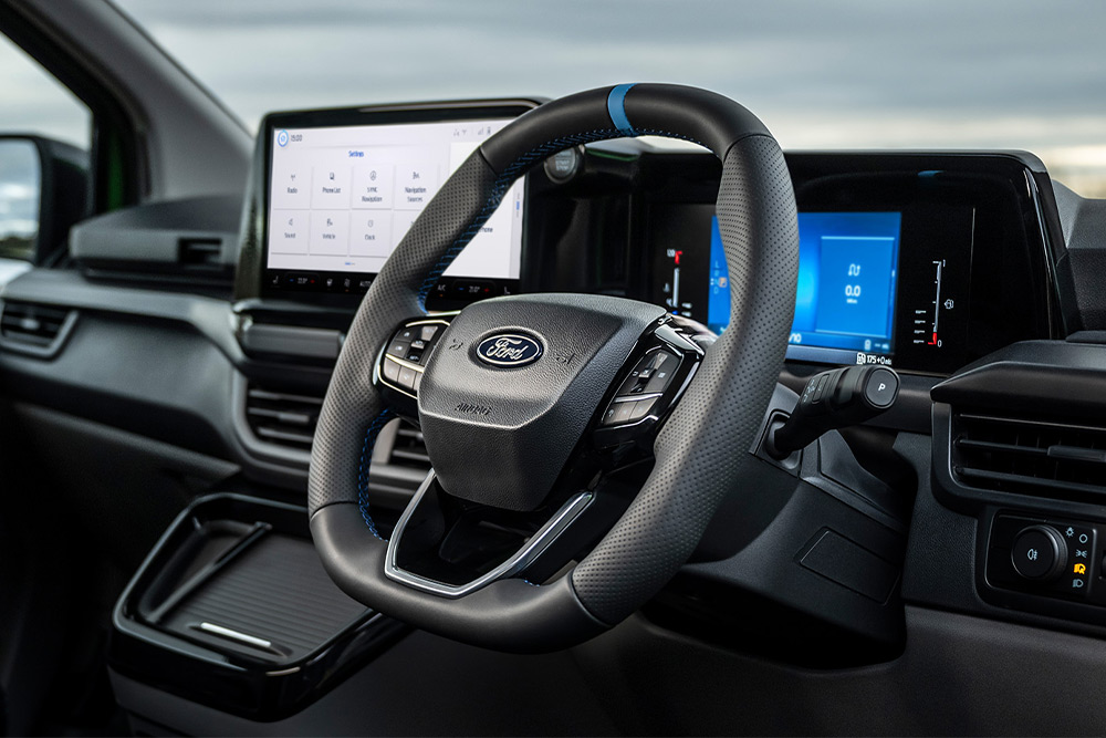 Interiorul unui Ford Transit Custom MS-RT cu volan, tablou de bord digital, planșă de bord și ecran tactil de infotainment.