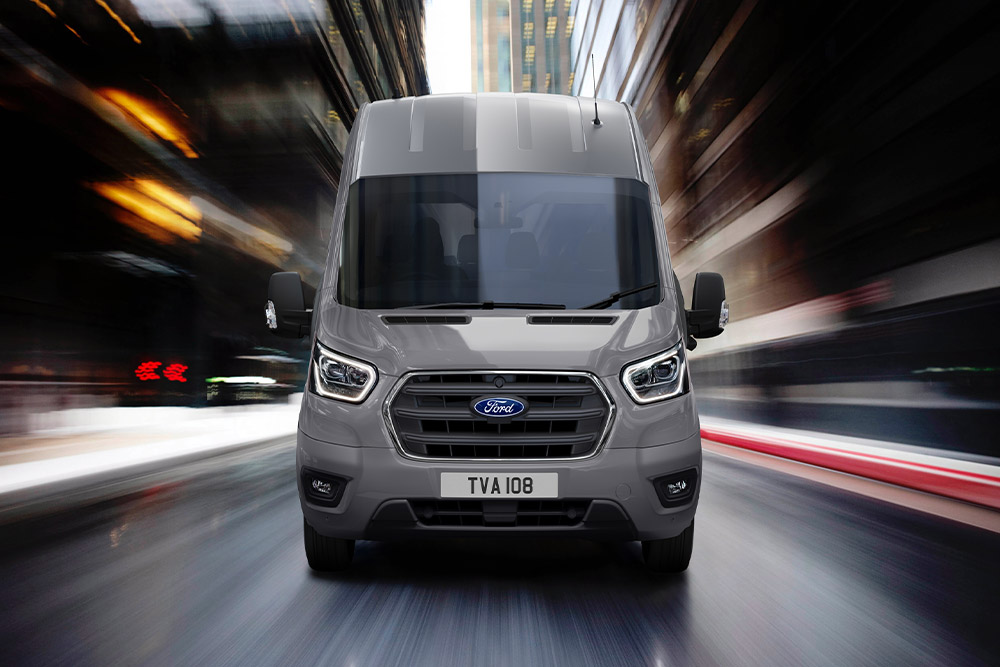 Front view of a Ford Transit Van driving in the city.